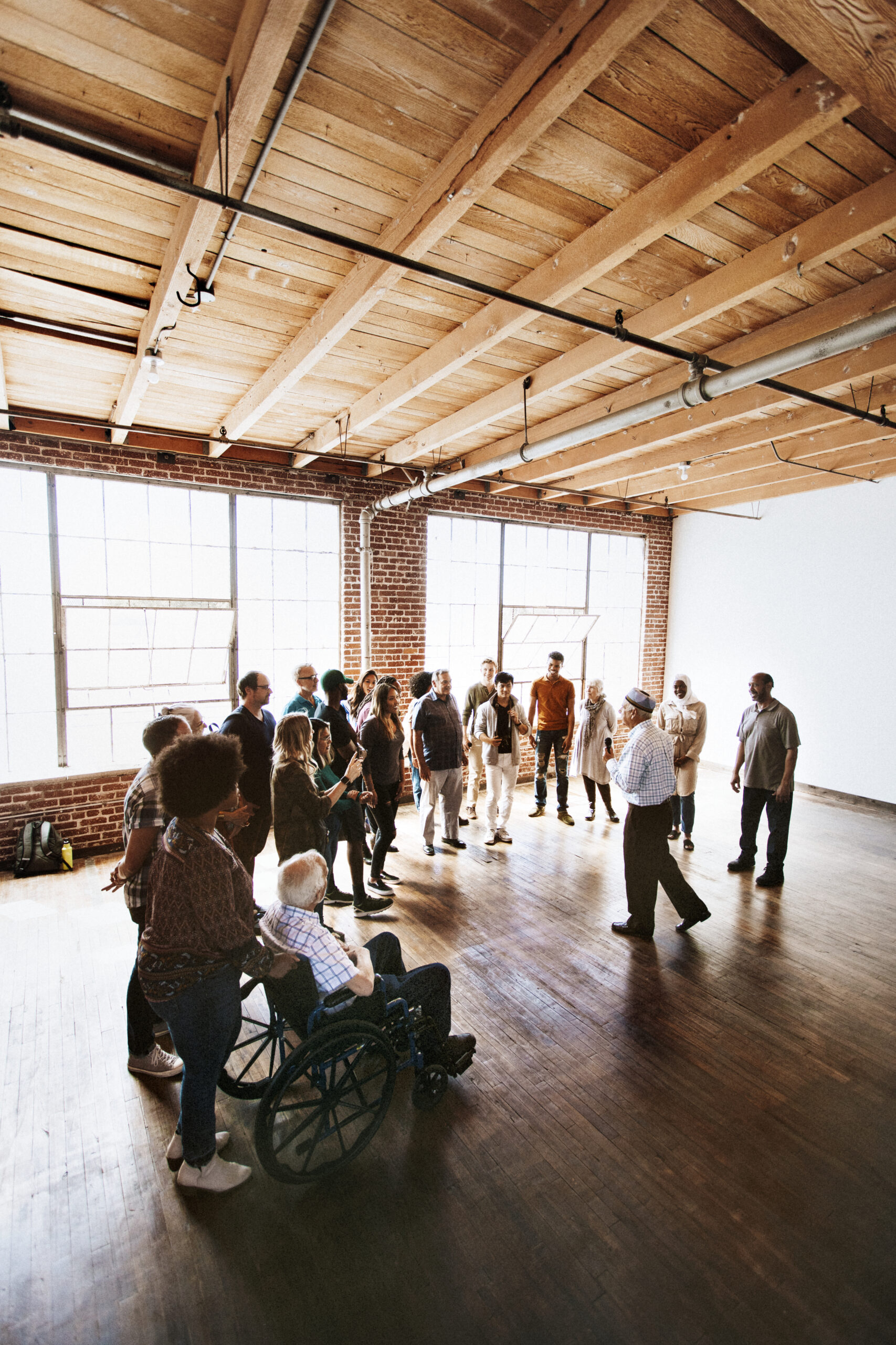 A diverse group of NDIS participants in Darwin attending a community engagement session in a bright indoor space.
