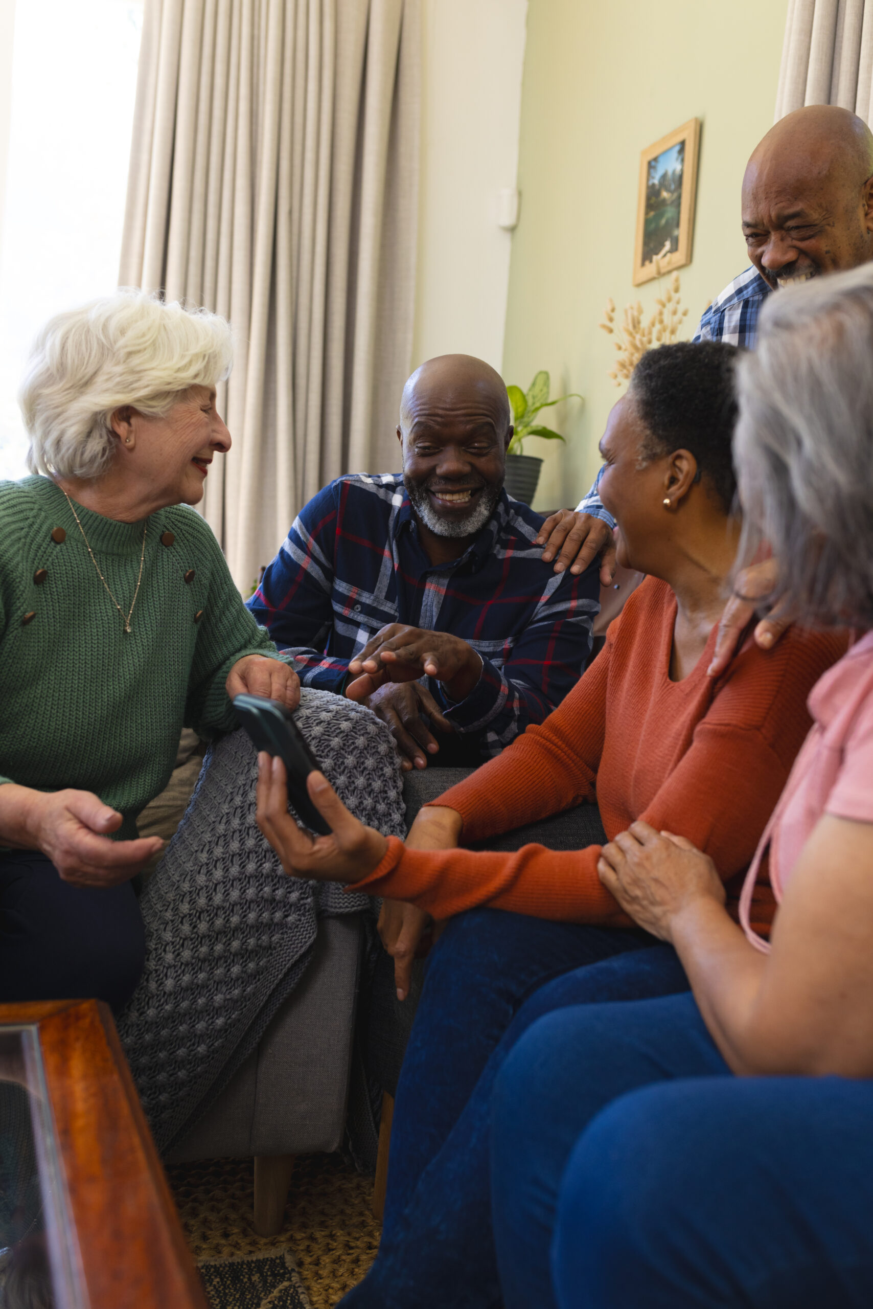 "Support workers and elderly individuals sharing a joyful conversation in a comfortable setting"