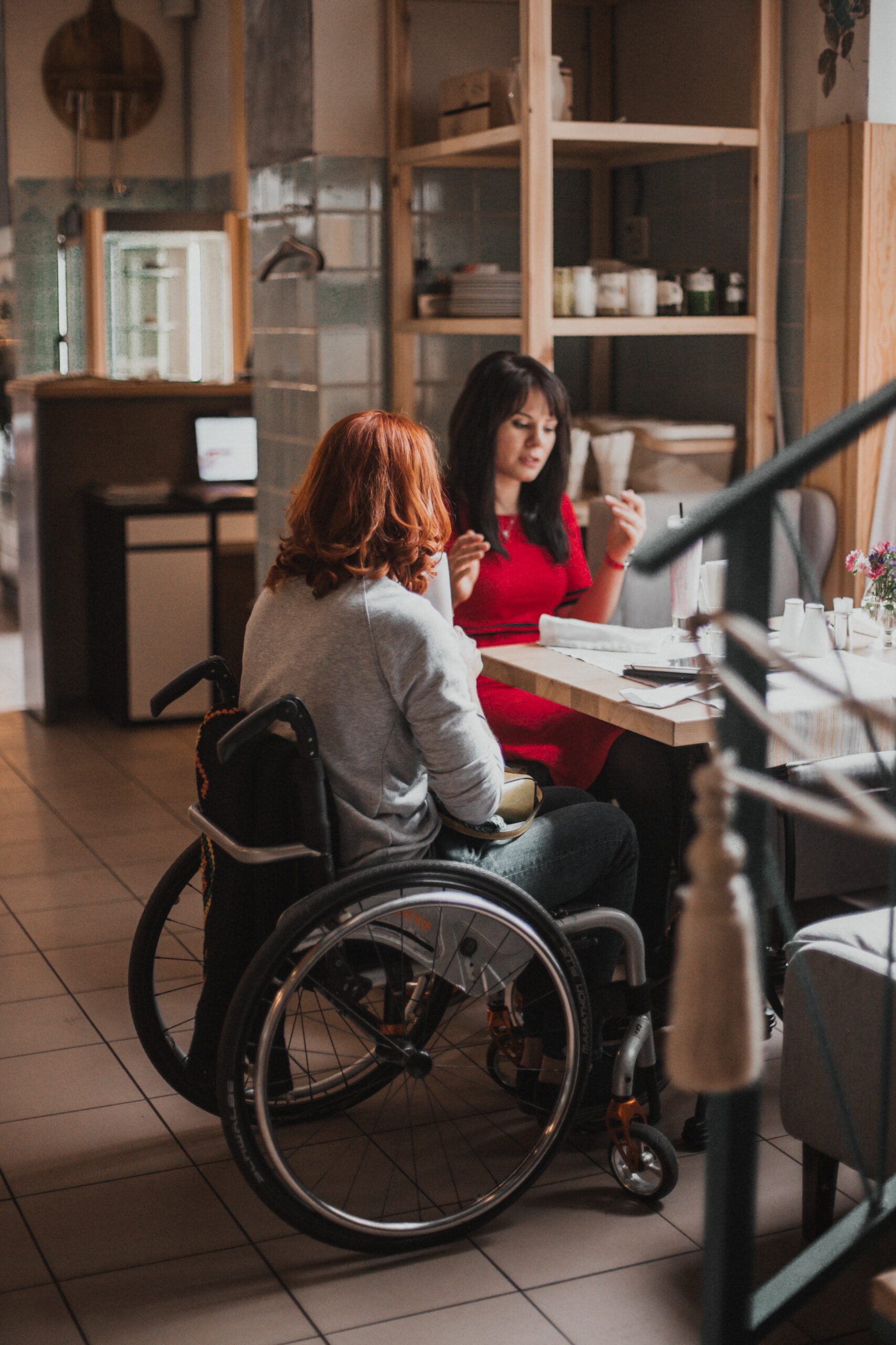 Support coordinator guiding NDIS participant in wheelchair – exploring life skills development eligibility and access