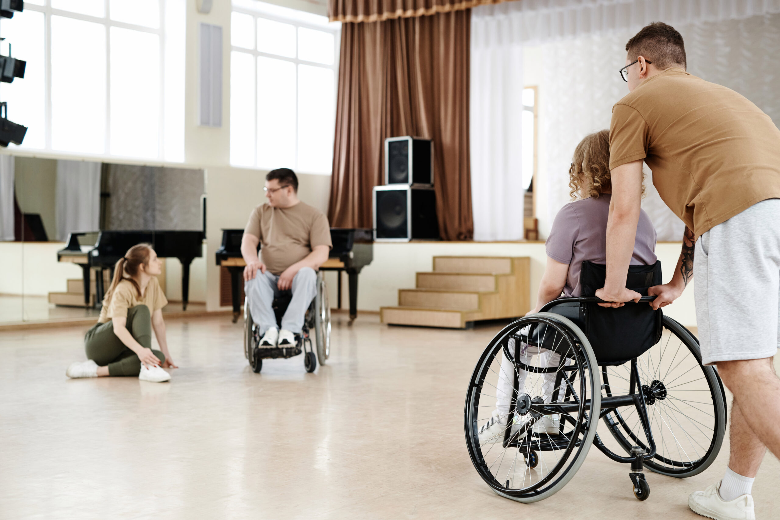 NDIS participants in wheelchairs engaging in group activities with support staff, representing shared independent living support.