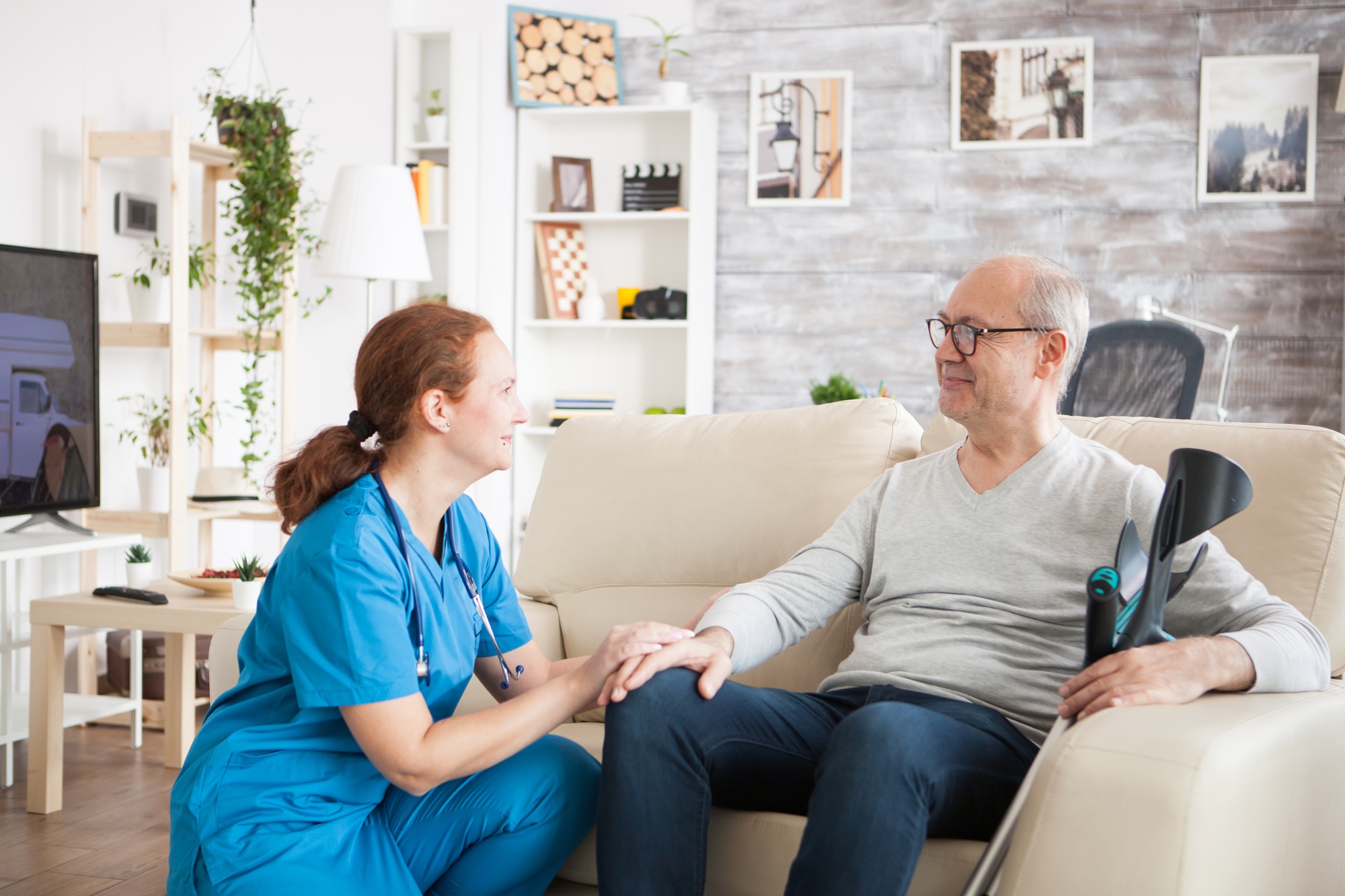Community nurse warmly supporting an older man at home, reflecting personalised care through Connectors Wellbeing services.