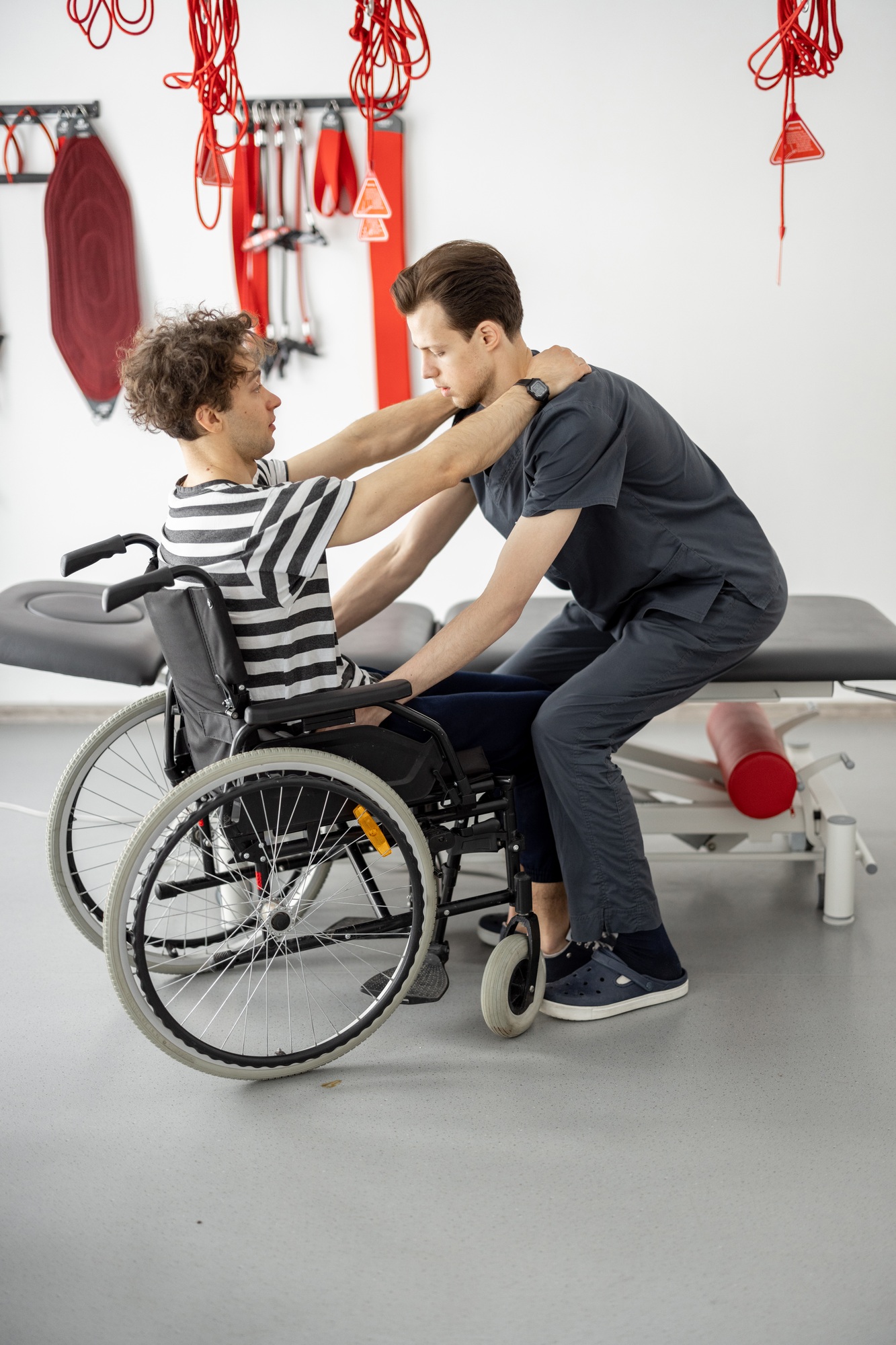 Support worker assisting a man in a wheelchair with daily living activities, highlighting NDIS support for independence.